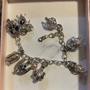 sterling silver charm bracelet with various pearl cage and other charms